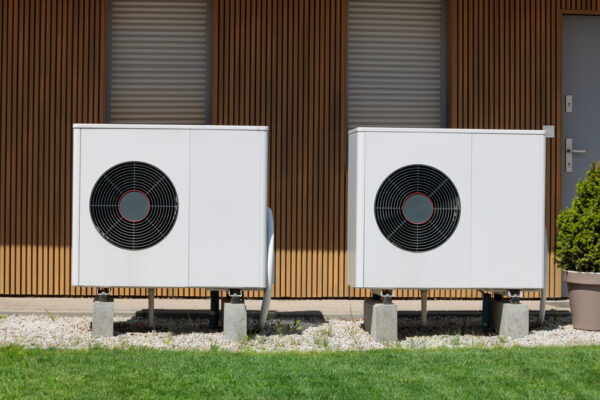 Air source heat pumps featured on modern house front. Renewable energy concept